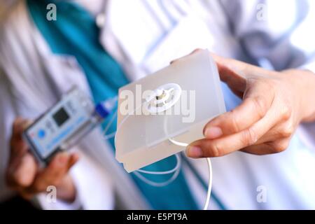 Doctor sosteniendo un catéter intraperitoneal externo conectado a una bomba de insulina, del departamento de endocrinología de la Pr Foto de stock