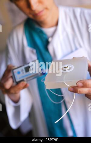 Doctor sosteniendo un catéter intraperitoneal externo conectado a una bomba de insulina, del departamento de endocrinología de la Pr Foto de stock