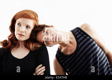 Retrato de estudio de joven apoyándose en el hombro de la mujer joven