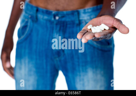 Sección intermedia de hombre con píldoras de vitaminas en la mano Foto de stock