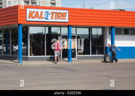 Kal Tire, un negocio canadiense de venta al por menor con el neumático de hombre rodando Foto de stock