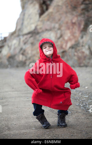 niño pequeño blanco vestido con una sudadera roja de mayor tamaño que se  divierte arrugando y bailando en la montaña Fotografía de stock - Alamy