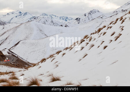 Cespitosas hierba en nieve, paisajes de montaña, Lindis Pass, Otago, Isla del Sur, Nueva Zelanda
