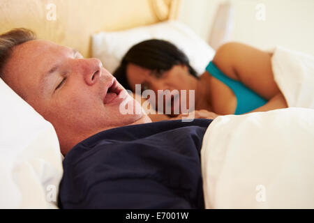 Par dormido en la cama con el hombre ronquido Foto de stock