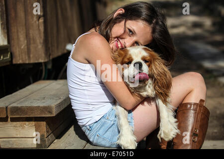 Retrato de niña sonriente abrazando perro en pasos