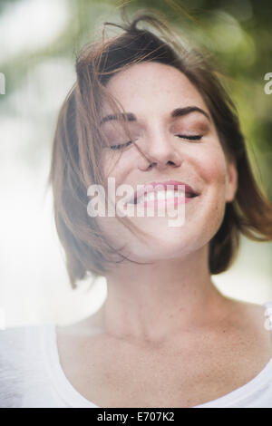 Close Up retrato de mujer adulta media sonriente con los ojos cerrados