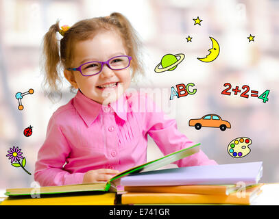 Niño feliz chica con gafas leyendo libros en la biblioteca