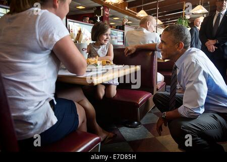 El presidente estadounidense, Barack Obama, conversa con una niña en el hoyo de carbón restaurante Julio 17, 2014 en Wilmington, Delaware.