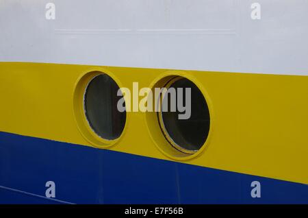 Dos portillas del barco en el fondo del tablero amarillo Foto de stock