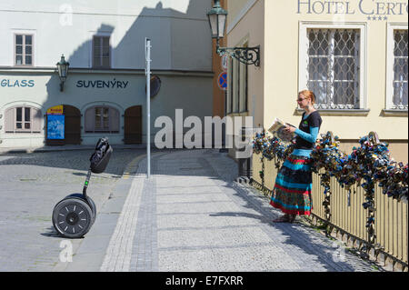 Un agente del Segway principales contra la barandilla de un puente cubierto con una serie de candados cerrados, Praga, República Checa.