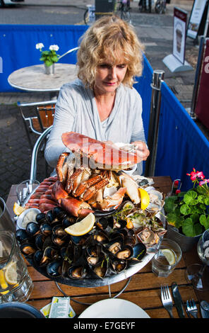 Mujer comiendo un plateau de fruits de mer con cangrejo fresco o un plato de mariscos frescos en el restaurante Brighton Reino Unido Fishy Fishy
