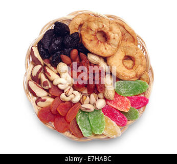 Las frutas secas y las nueces en un recipiente de madera de mimbre sobre fondo blanco. Foto de stock