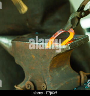 Herrero forja un hierro candente en la forja. martillo de forja de  estructuras metálicas en un yunque de hierro fundido al aire libre en la  naturaleza Fotografía de stock - Alamy