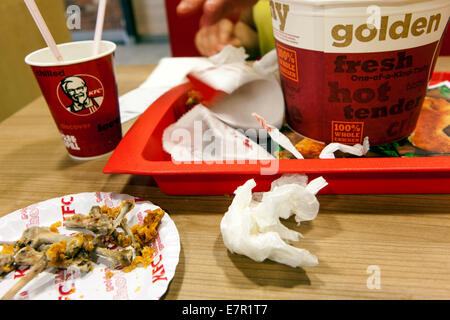 Sobra de comida en una bandeja, taza de café, cubo KFC residuos KFC Foto de stock