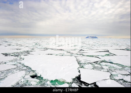 Pequeña isla en el mar de Ross, en la Antártida, con bloques de hielo en el primer plano. Foto de stock
