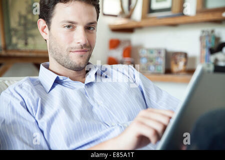 Hombre utilizando tablet digital en casa Foto de stock