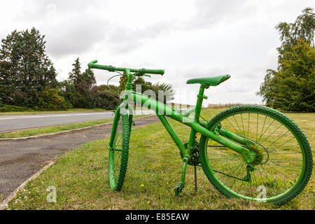 Vintage verde en bicicleta en un campo verde junto a la carretera.