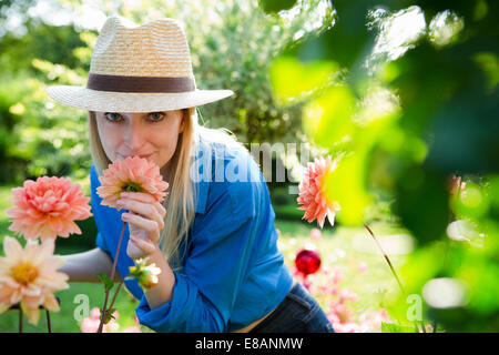 Retrato de mujer adulta media oliendo flores de jardín