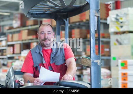 Retrato de conductor de carretilla elevadora en almacén almacén de hardware Foto de stock