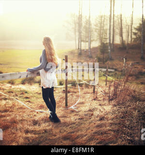 Mujer de pie cerca en el paisaje rural mirando a la vista, Noruega Foto de stock