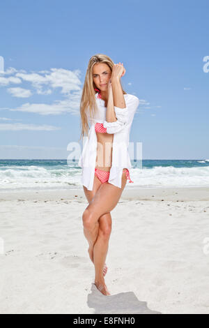Mujer joven en la playa de pie en la pose de águila, Ciudad del Cabo, Cabo Occidental, Sudáfrica
