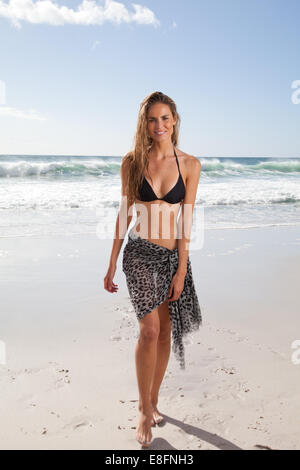 Mujer joven en bikini y sarong caminando por la playa, Ciudad del Cabo, Cabo Occidental, Sudáfrica