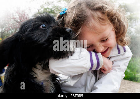 Chica feliz jugando con un perro perrito