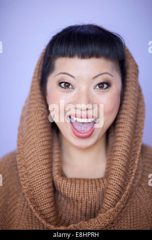 Mujer asiática con cálidos fuzzy suéter de cuello del salpicadero. Corte de pelo corto con flequillo lindo.