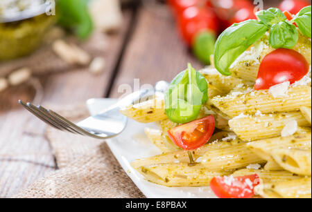 Porción de pasta (Penne con Pesto Albahaca) sobre fondo de madera Foto de stock