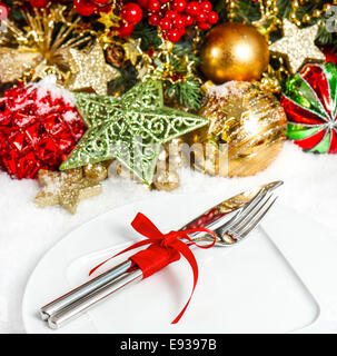 Las ramas de un árbol de Navidad con adornos en rojo y oro. Lugar de mesa festiva ajuste el enfoque selectivo. Foto de stock