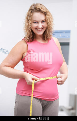 Feliz Mujer Plus Size la medición de cintura en el baño. Foto de stock