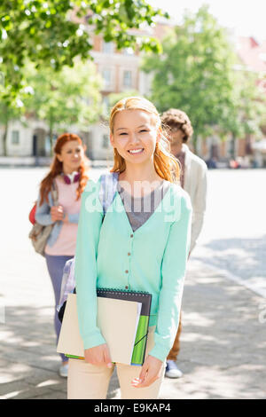 Retrato de joven estudiante con amigos en el fondo en la calle