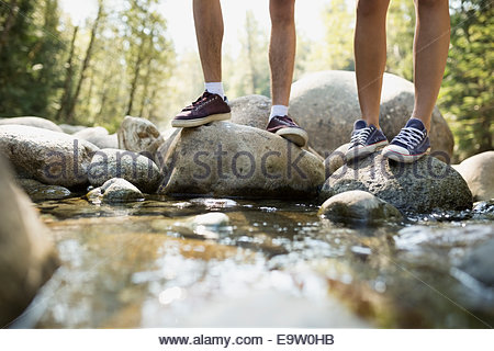 Amigos que estaban de pie sobre las rocas en creek