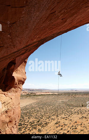 Mujer rappel desde arch, Moab, Utah, EE.UU. Foto de stock