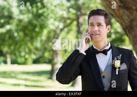 El novio con teléfono móvil en el jardín