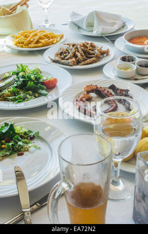 Mesa en restaurante griego. Salat y peces
