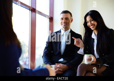Empresarios sonrientes tener coffee break en la oficina