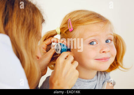 Médico examina chica del oído con lápiz linterna médica. Audiólogo examinar  poco paciente con linterna ENT Fotografía de stock - Alamy