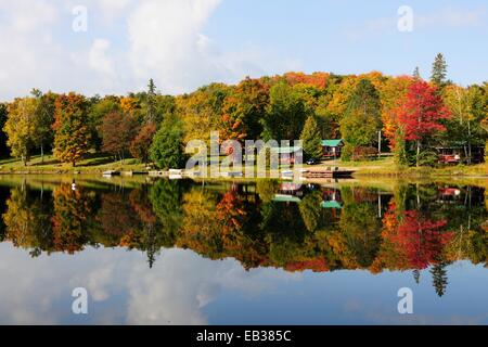 Bosque en colores otoñales y casas reflejadas en Galeairy Lago, Lago y bosque paisaje típico del Escudo Canadiense Foto de stock