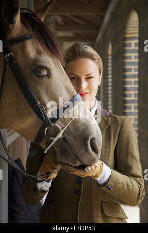 Mujer en traje de equitación a caballo