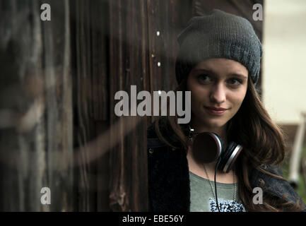 Retrato de una adolescente en el exterior, llevar sombrero y auriculares alrededor del cuello, Alemania Foto de stock