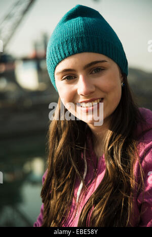 Close-up retrato de adolescente afuera usando el toque, sonriendo y mirando a la cámara, Alemania Foto de stock