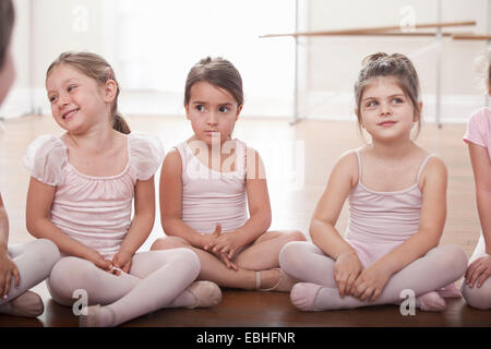 El grupo de niñas sentados en el suelo en la escuela de ballet