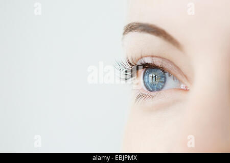 Estudio cerca de la mitad de los womans adulto mirando blue eye Foto de stock