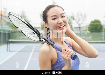 Retrato de mujer joven jugador de tenis en la cancha de tenis Foto de stock