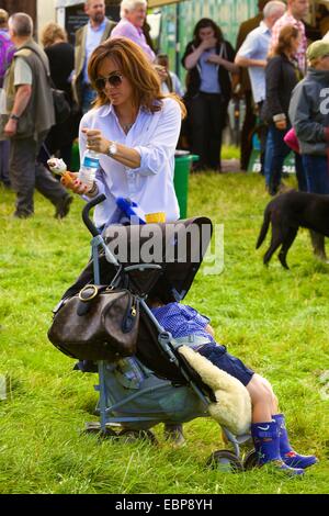 Madre con su hijo en buggy en el país demuestran Lowther. Foto de stock