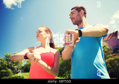 Gente sonriente con ritmo cardíaco relojes outdoors Foto de stock