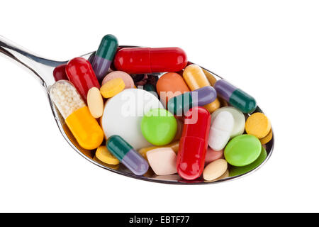 Muchas tabletas de diferentes colores en una cuchara. El abuso de drogas