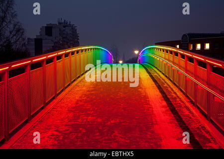 Una fotografía nocturna de un puente iluminado por luces rojas