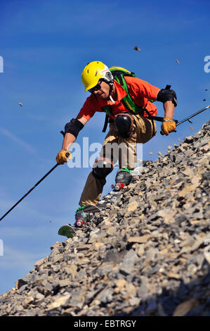 Esquiador freeride va cuesta abajo en la ladera rocosa Foto de stock